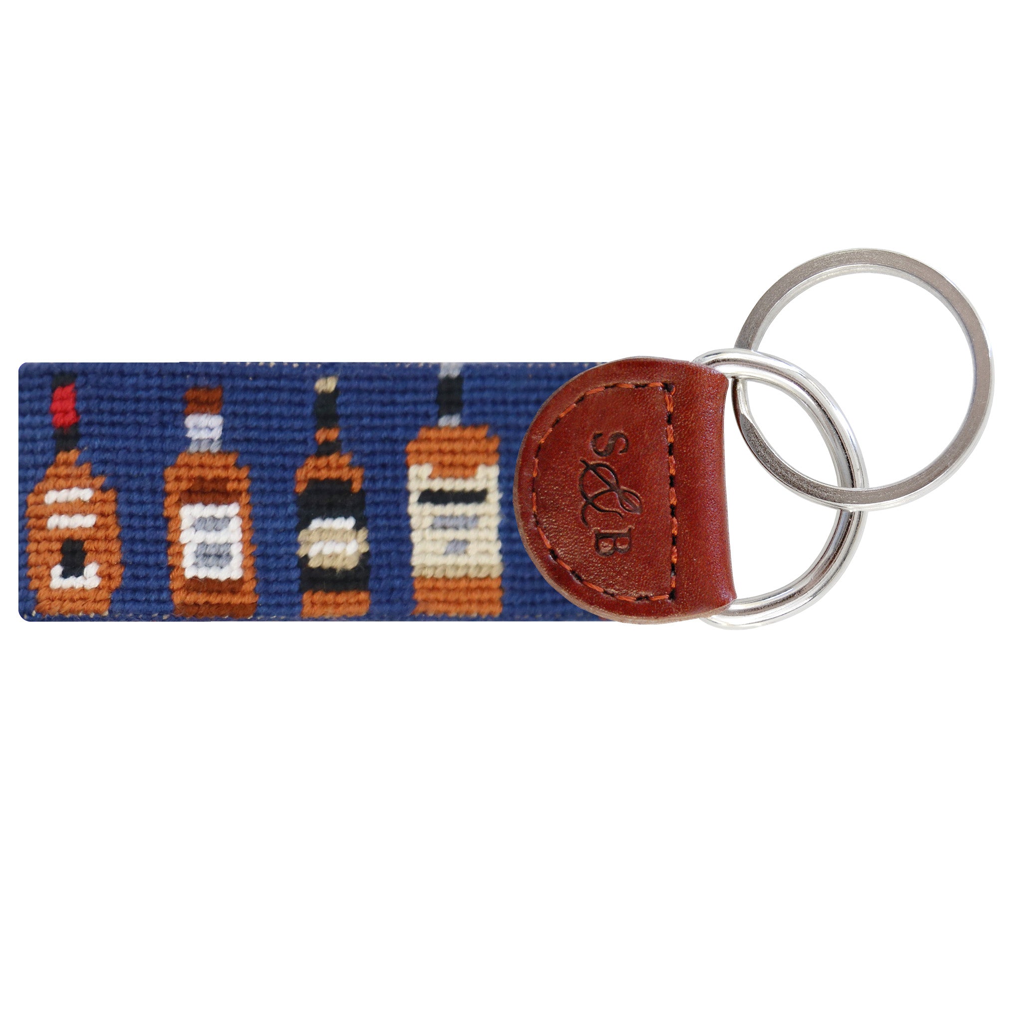 Classic navy needlepoint key fob featuring repeating bourbon bottles in various label colors, brown leather trim, and a metal key ring.