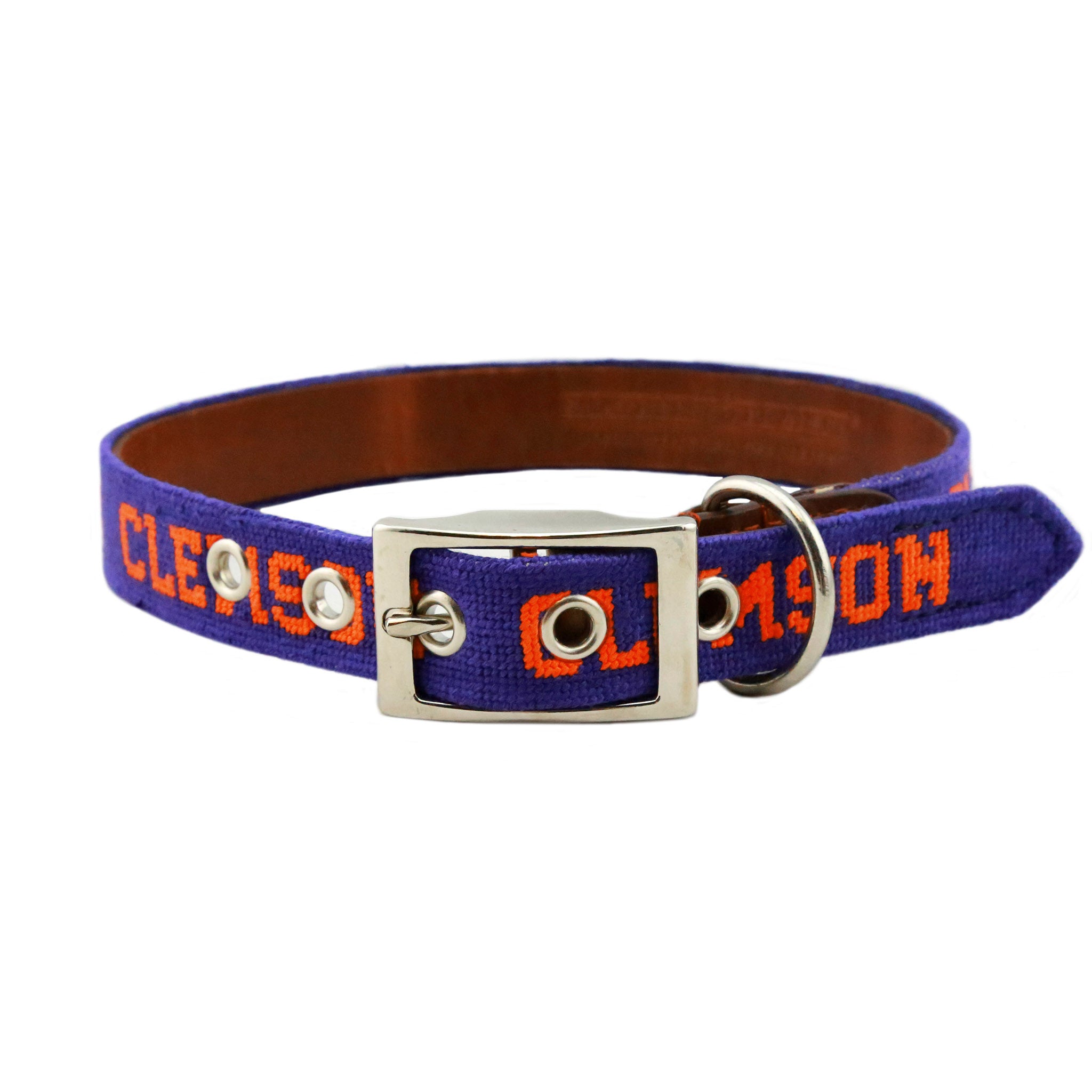Orange needlepoint dog collar featuring the Clemson text logo stitched in white, with brown leather backing and a metal buckle for secure fastening