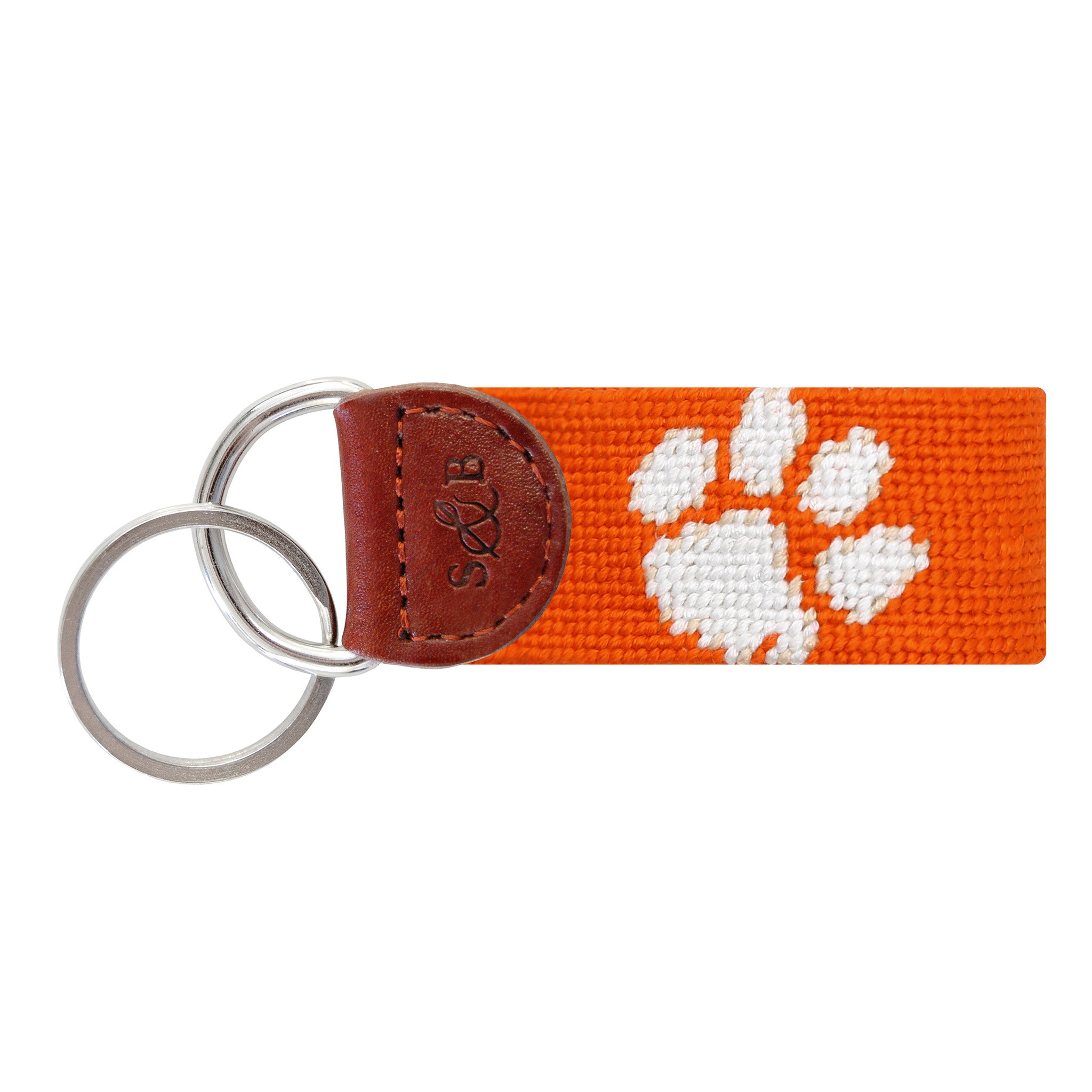 Orange needlepoint key fob displaying a white Clemson paw logo, with brown leather trim and a metal key ring.