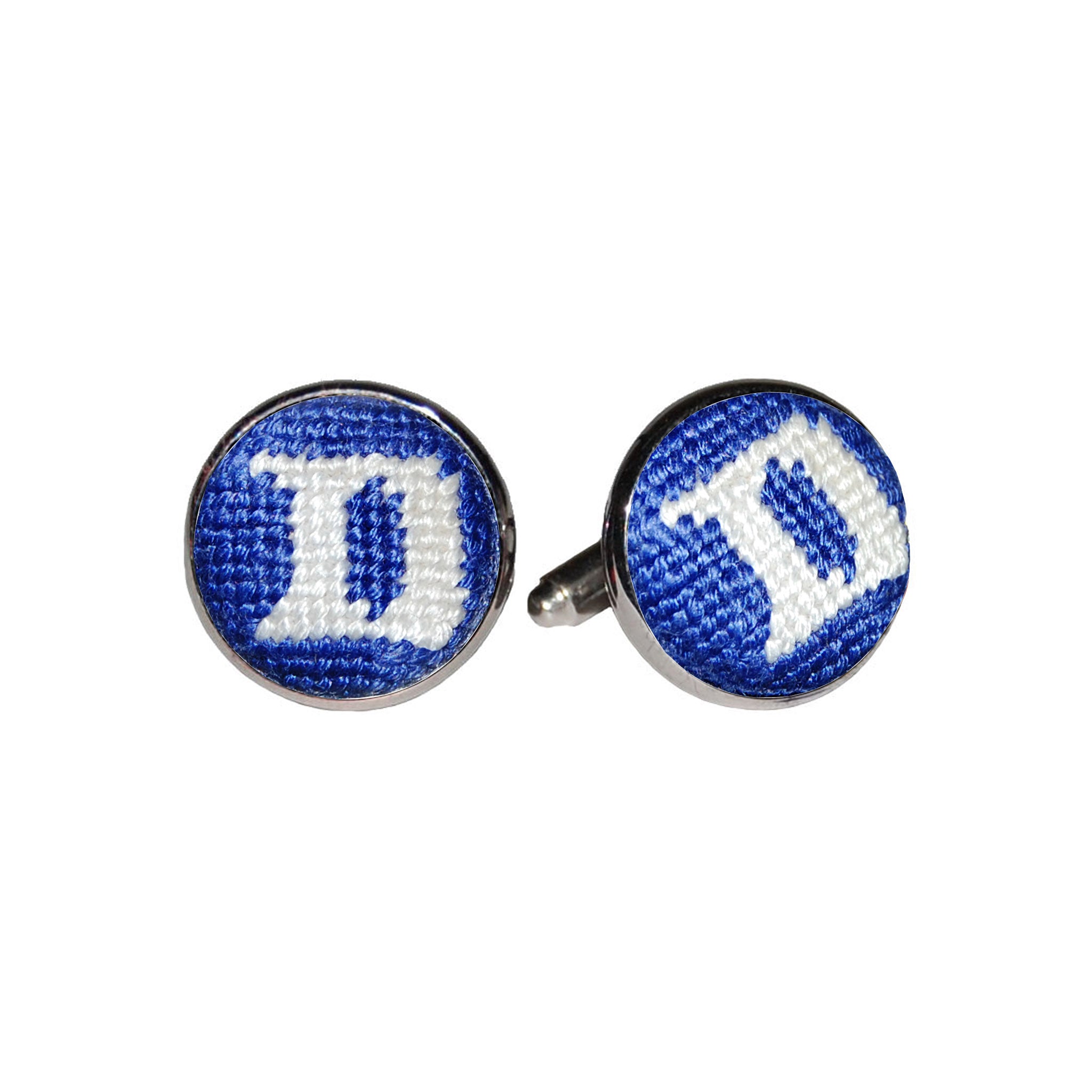 Duke cufflinks featuring the blue and white collegiate logo stitched in needlepoint, set into a silver-plated cufflink.