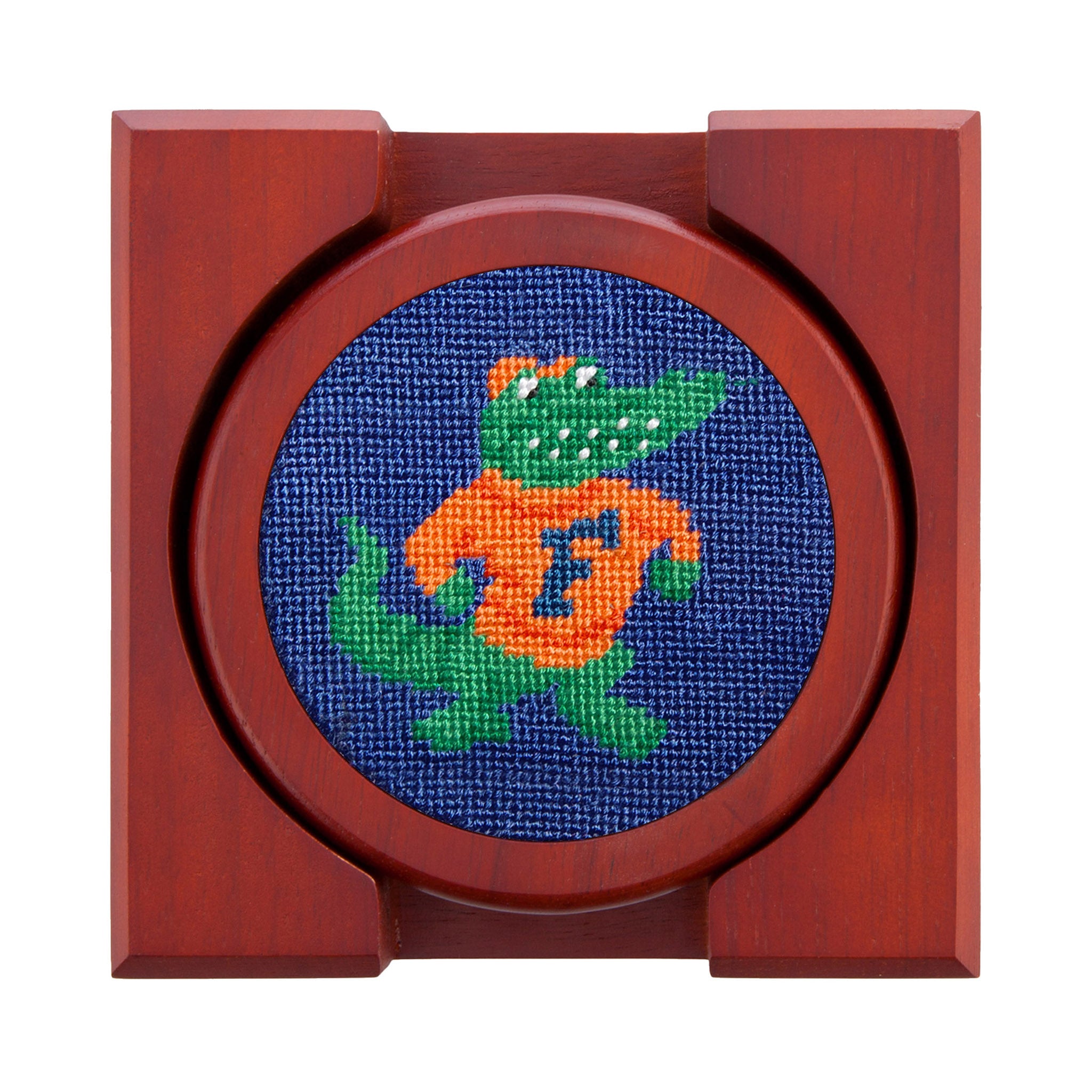 Royal blue needlepoint coasters with bold orange accents and “F” logos, backed with chestnut wood.