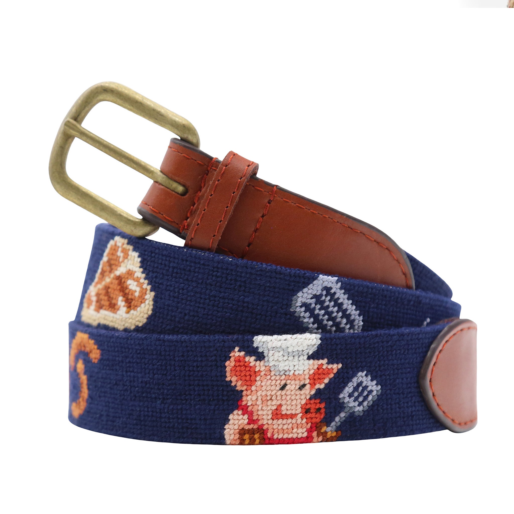 Grill Master Needlepoint Belt Dark Navy Final Sale coiled, with brown leather trim and a brass buckle