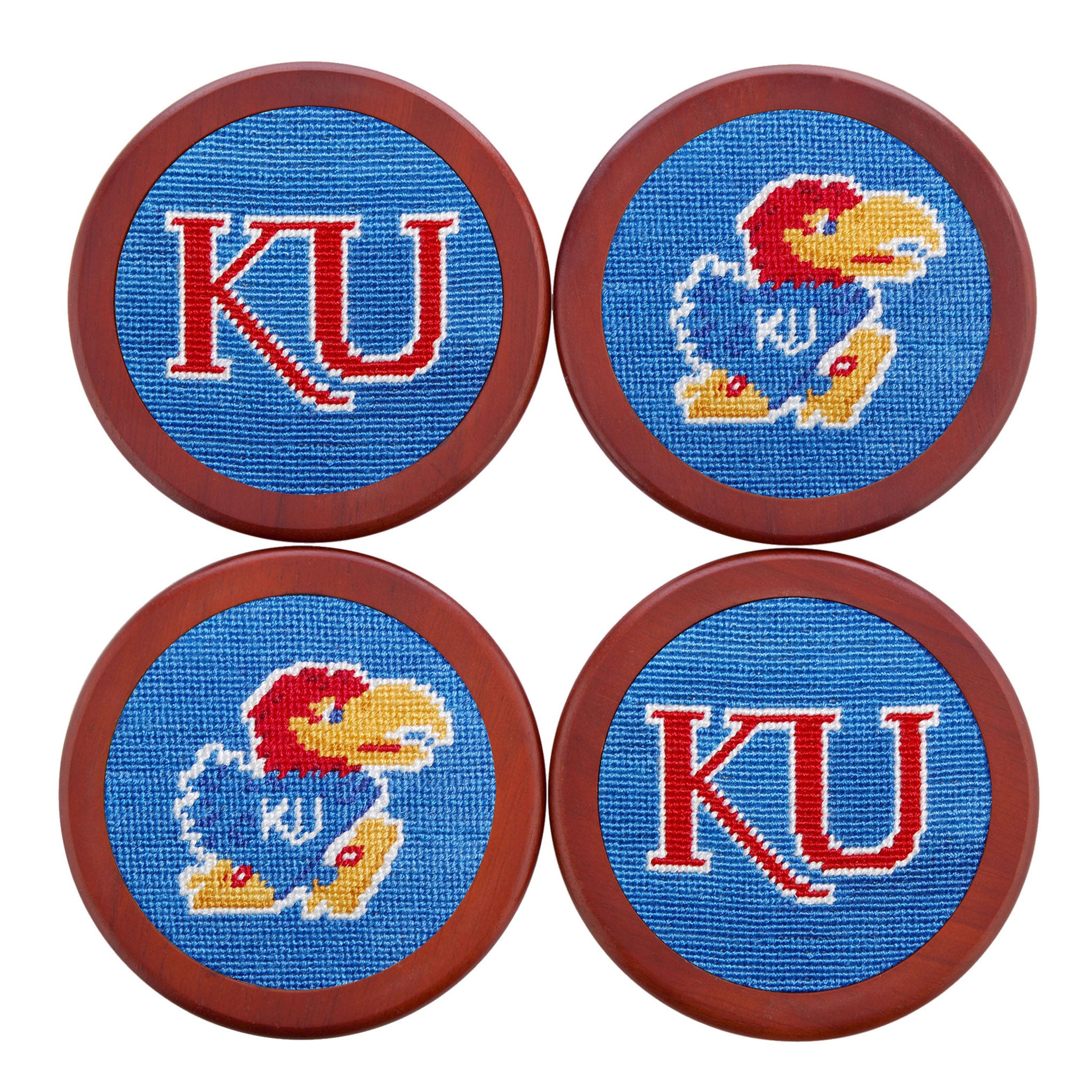 Blue needlepoint coaster set showcasing the Kansas Jayhawk logo in red and yellow, with chestnut wood backing.