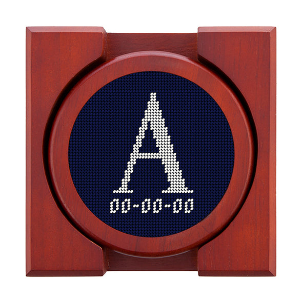 Dark Navy needlepoint coaster set featuring a white large embroidered letter above a custom date, framed with chestnut wood
