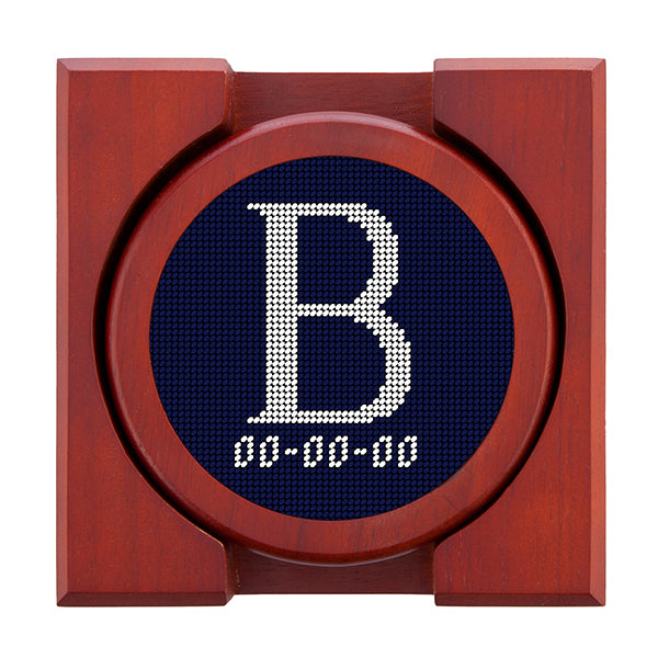 Dark Navy needlepoint coaster set featuring a white large embroidered letter above a custom date, framed with chestnut wood
