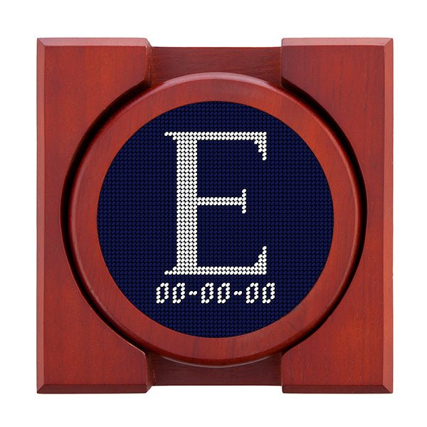 Dark Navy needlepoint coaster set featuring a white large embroidered letter above a custom date, framed with chestnut wood