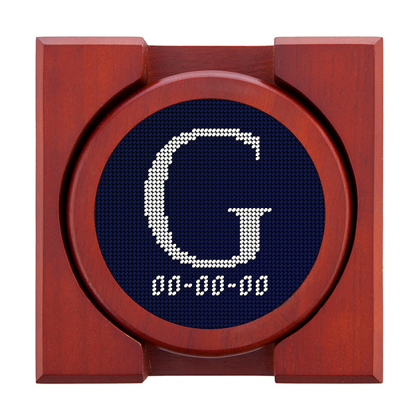 Dark Navy needlepoint coaster set featuring a white large embroidered letter above a custom date, framed with chestnut wood