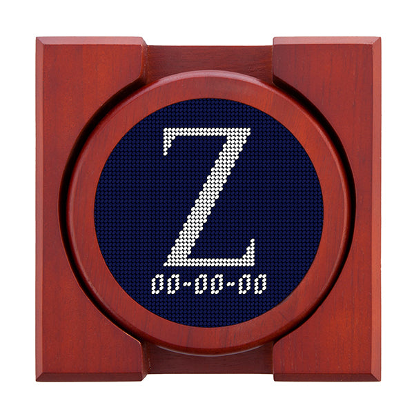 Dark Navy needlepoint coaster set featuring a white large embroidered letter above a custom date, framed with chestnut wood