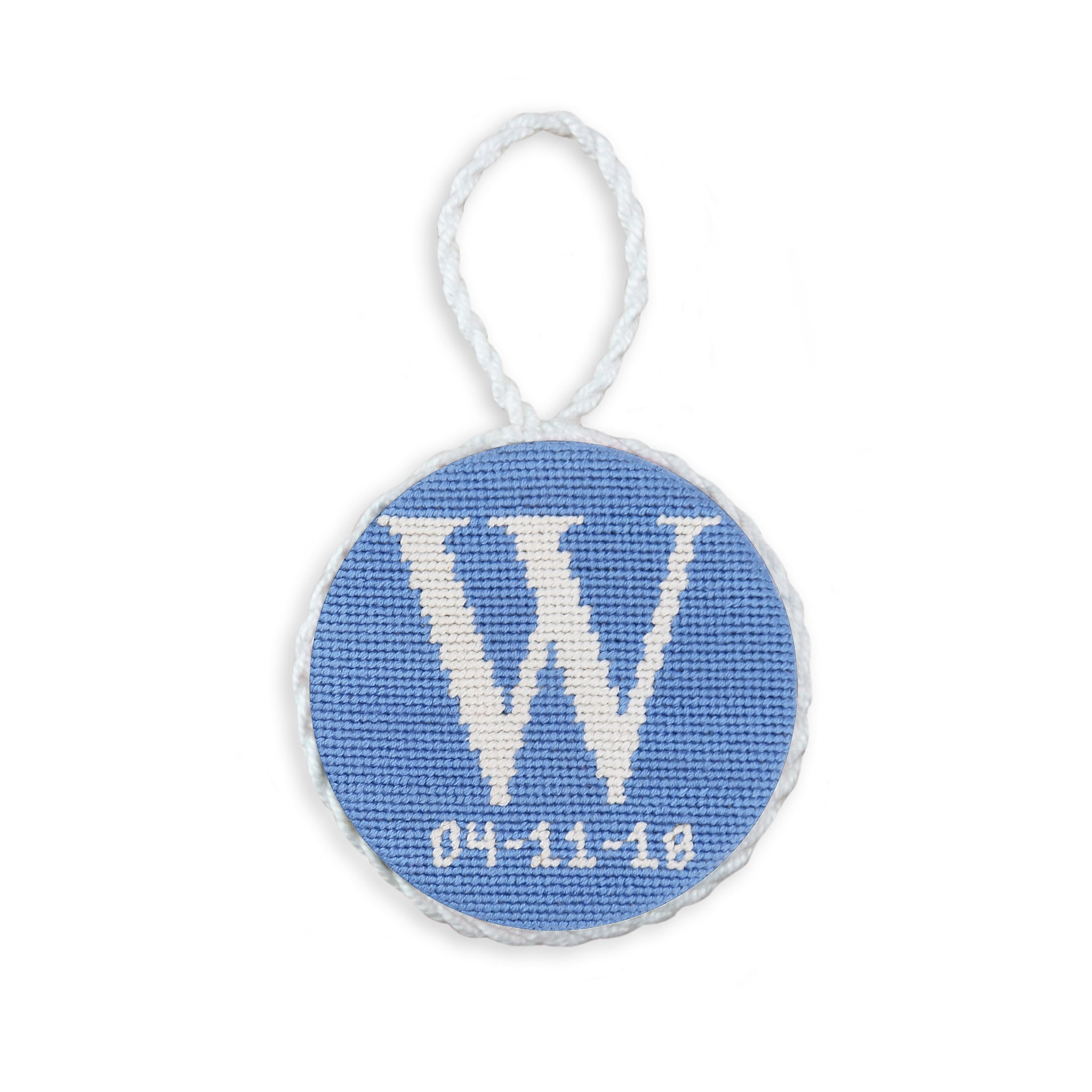 Baby blue needlepoint ornament with a scripted letter and date, white hanging cord.