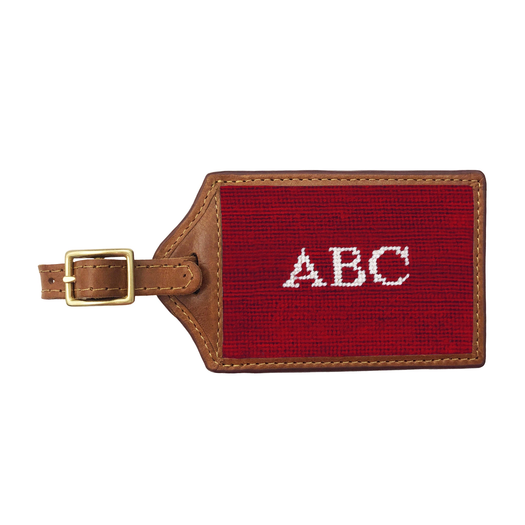 Navy needlepoint luggage tag with a white anchor and monogram initials in a nautical design, brown leather trim, and an ID window on the back.