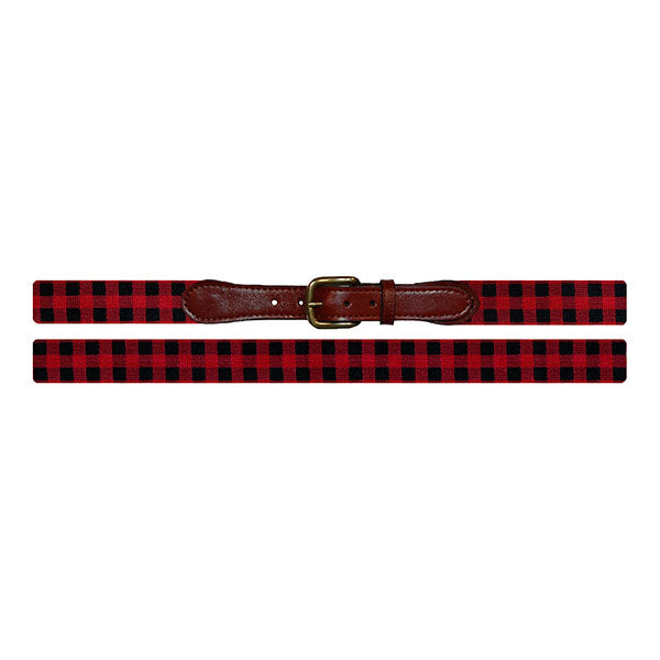 Red and black checkered belt with a brown leather, brass buckle on a white background
