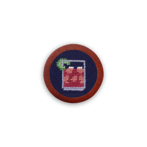 Dark navy golf ball marker with the phrase “Make a Transfusion” stitched in white needlepoint.