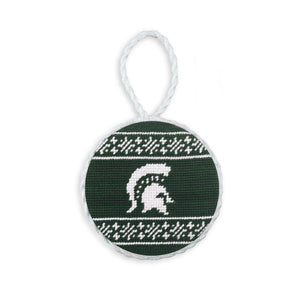 Dark pine needlepoint ornament featuring the Michigan State Spartan logo and a white hanging cord.