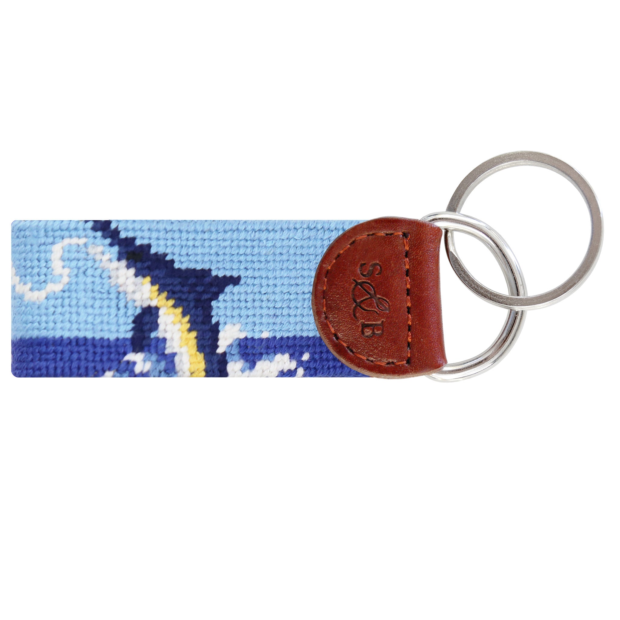 Blue needlepoint key fob with a white fishing boat and marlin design, brown leather trim, and a metal key ring.