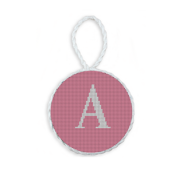 Pink needlepoint ornament featuring a white large embroidered letter above a custom date, framed with decorative stitching and finished with a festive hanging loop.