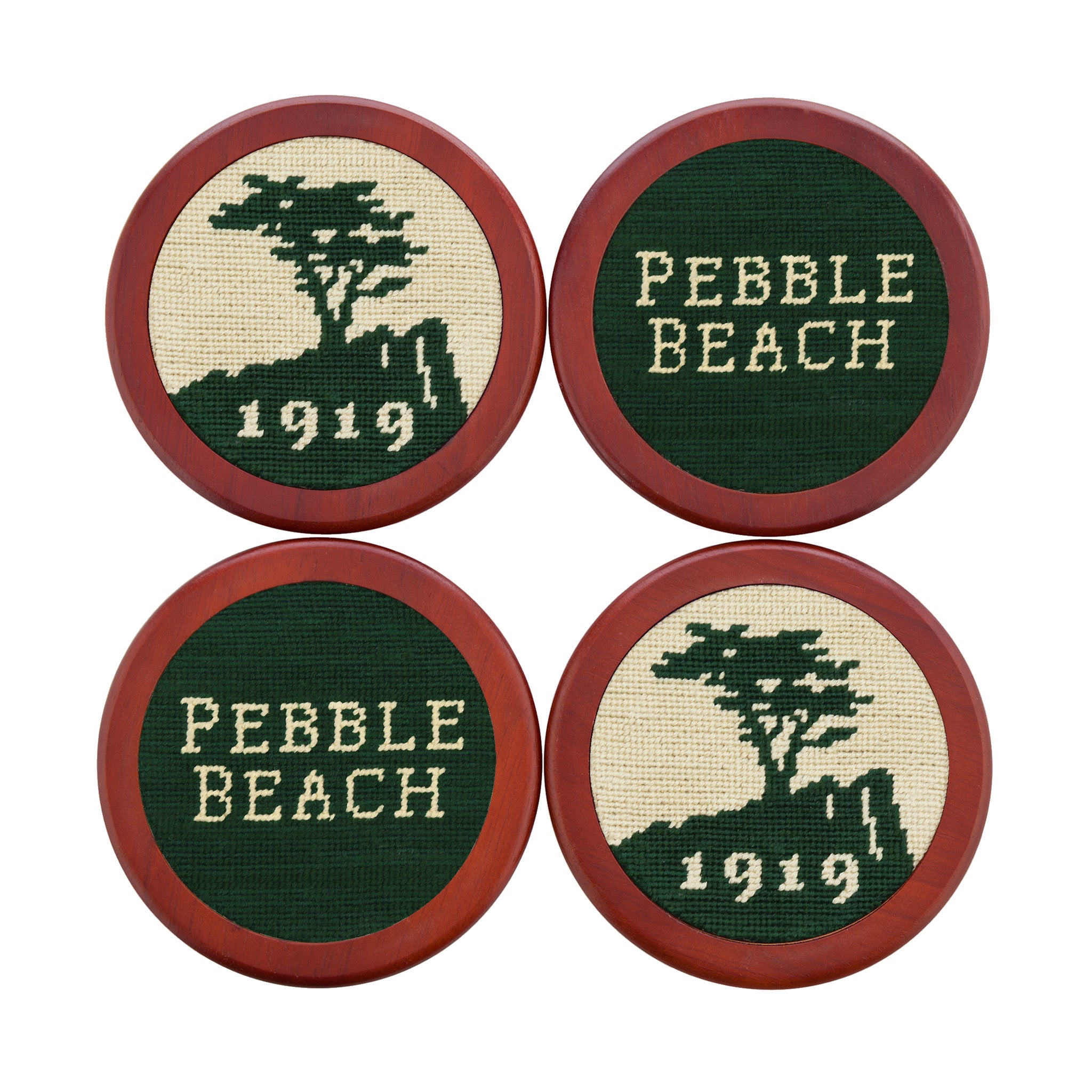 Hunter green coasters featuring the stacked Pebble Beach logo stitched in white and navy, shown laid flat.