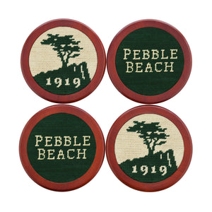Hunter green coasters featuring the stacked Pebble Beach logo stitched in white and navy, shown laid flat.