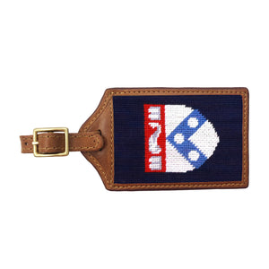 Navy needlepoint luggage tag with the red Pennsylvania “P” logo, brown leather trim, and an ID window on the back.