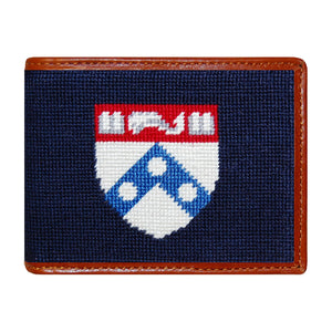 Pennsylvania navy needlepoint bi-fold wallet with white “PENN” text and brown leather trim, shown from primary angle.