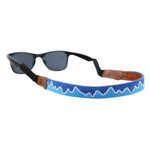 Blue needlepoint sunglass strap featuring the Ridgeline stitch-out design, with leather backing and cotton wrapped connectors for secure wear