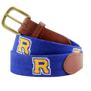 Rollins Needlepoint Belt Dark Royal coiled, with brown leather trim and a brass buckle