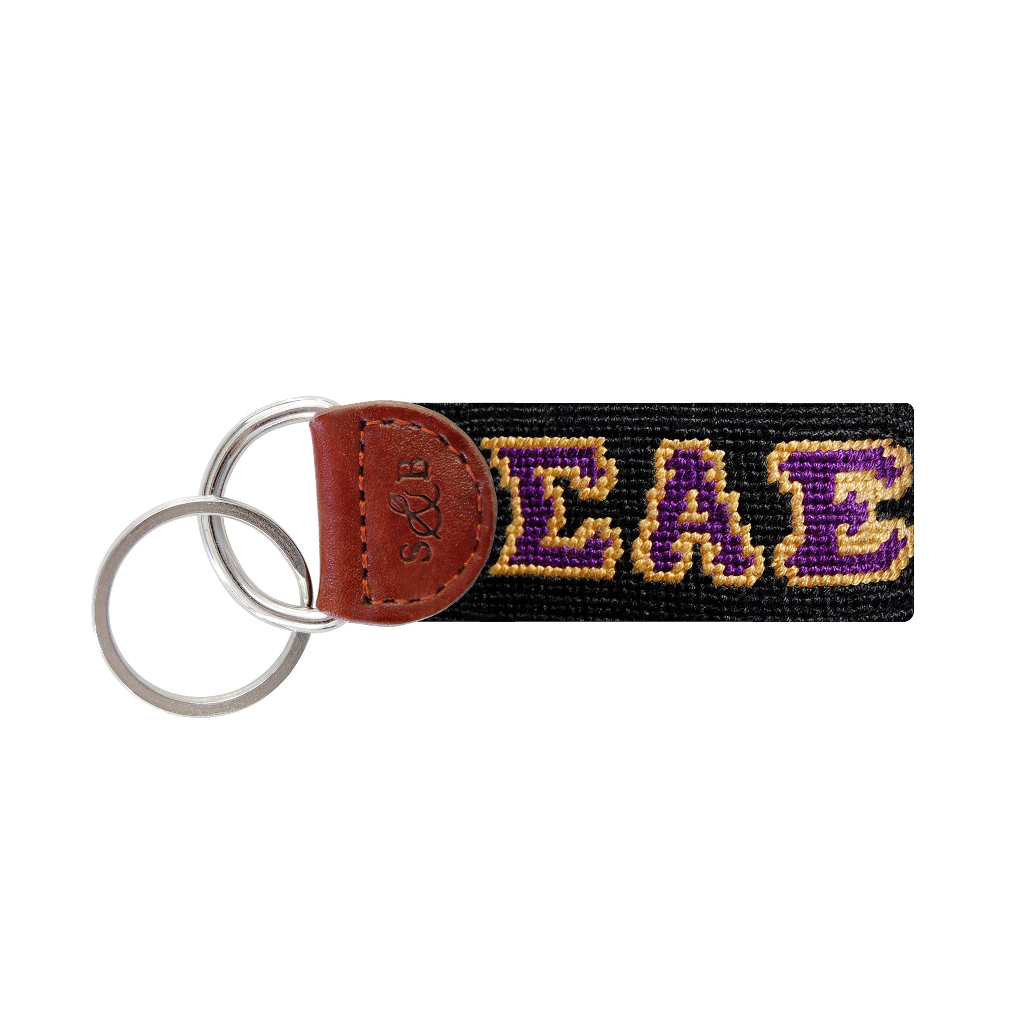 Navy needlepoint key fob featuring the Greek letters ΣΑΕ in gold, brown leather trim, and a metal key ring.