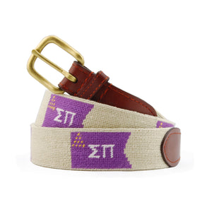 Sigma Pi Needlepoint Belt coiled, with brown leather trim and a brass buckle