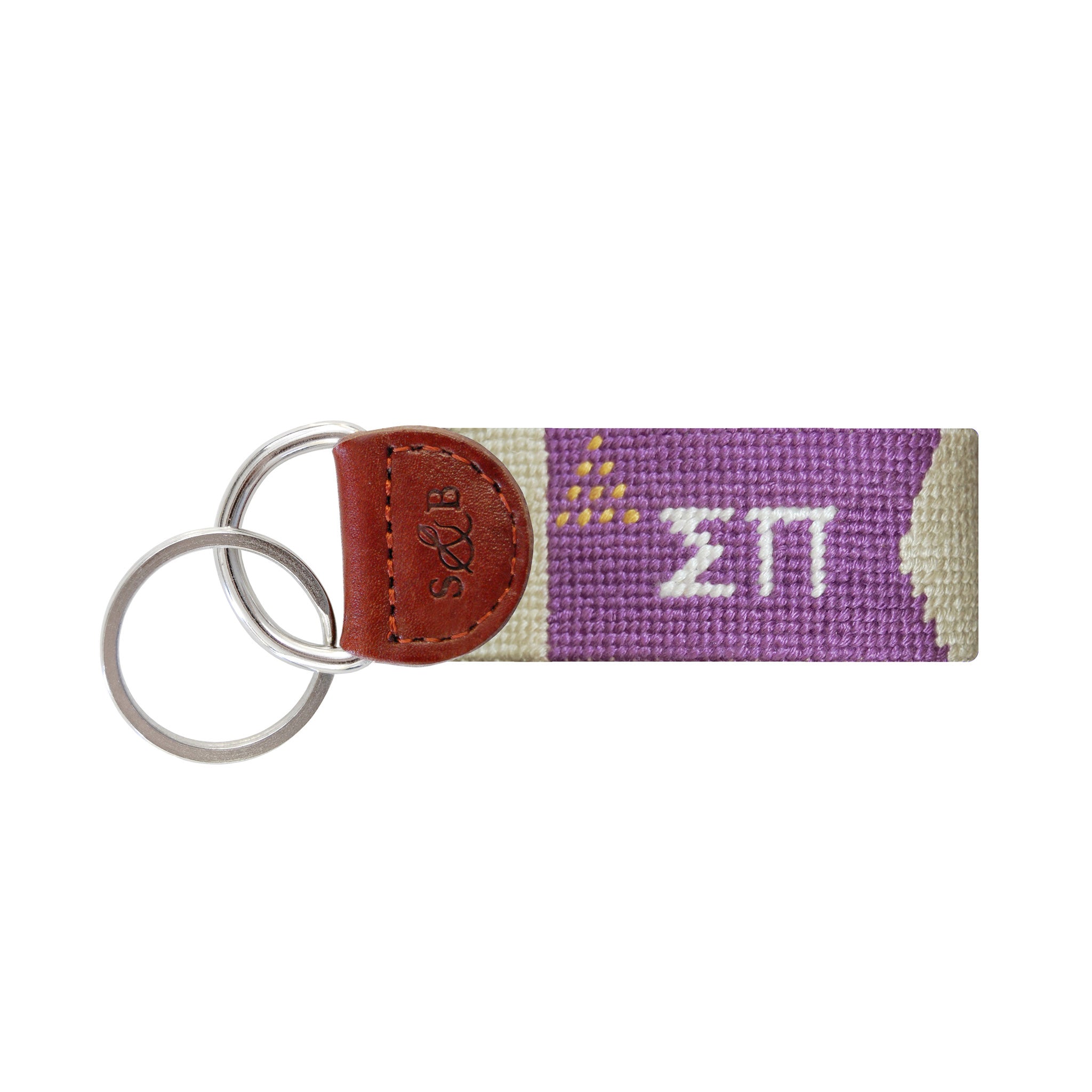 Purple needlepoint key fob displaying the Greek letters ΣΠ in white, brown leather trim, and a metal key ring.