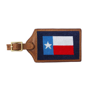 Dark navy needlepoint luggage tag with a Texas flag design, brown leather trim, and an ID window on the back.