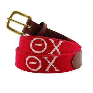 Theta Chi Needlepoint Belt coiled, with brown leather trim and a brass buckle