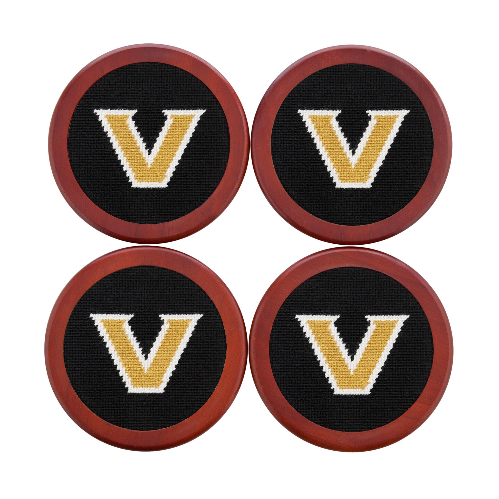 Black coasters featuring the gold Vanderbilt “V” logo in needlepoint, shown laid flat.