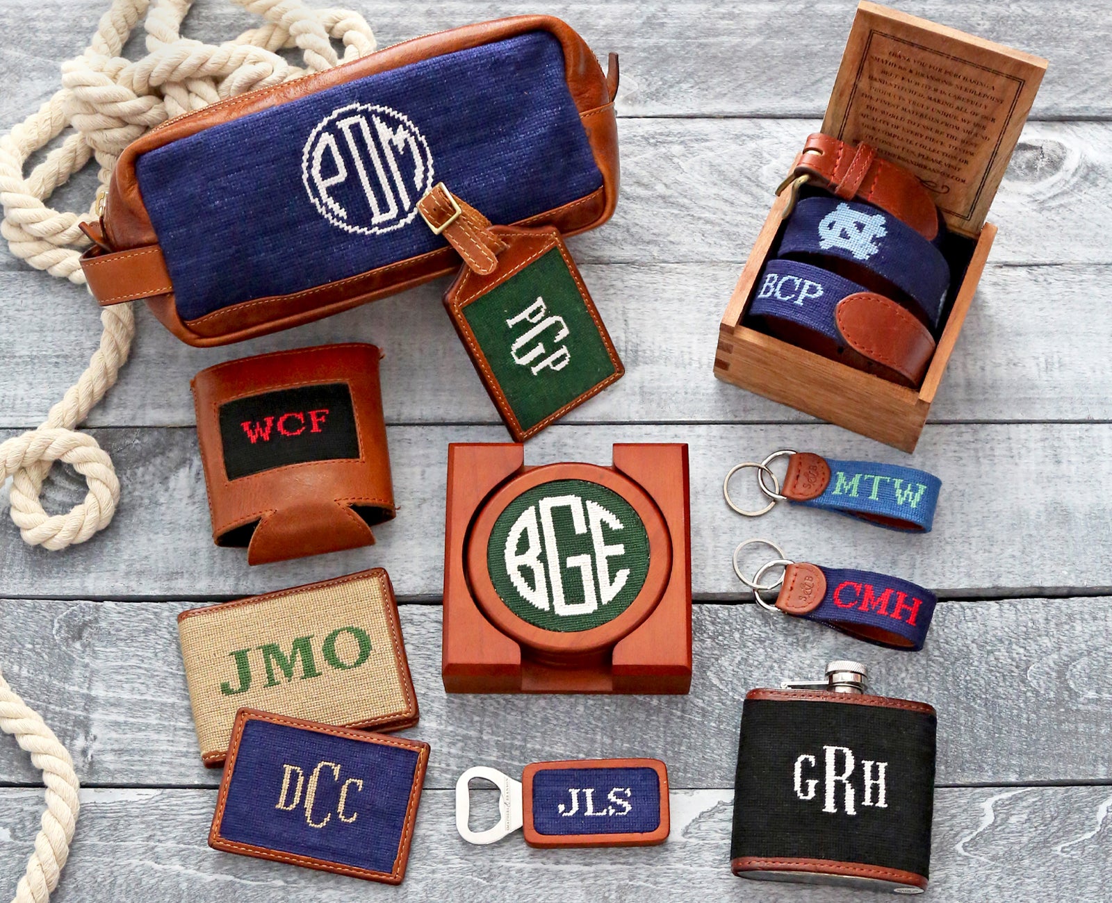 Assortment of different needlepoint accessories showcasing personalization options, laid out on wooden planks