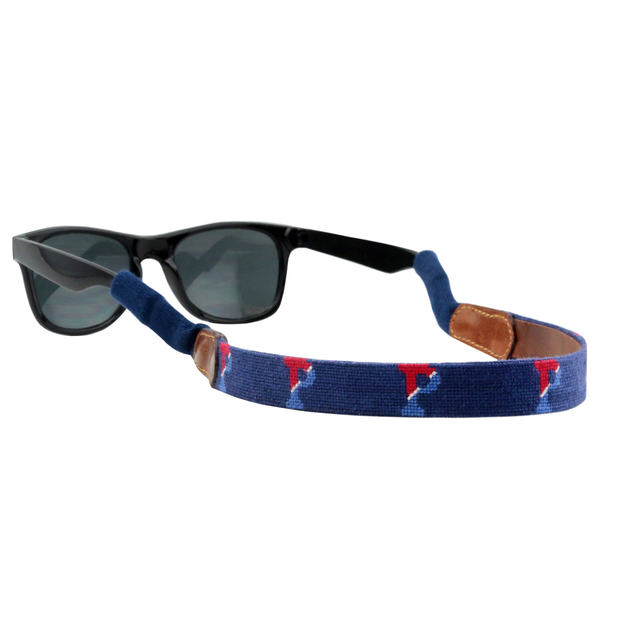 Navy needlepoint sunglass strap featuring the Pennsylvania logo stitched in gold, with leather backing and cotton wrapped connectors for secure wear