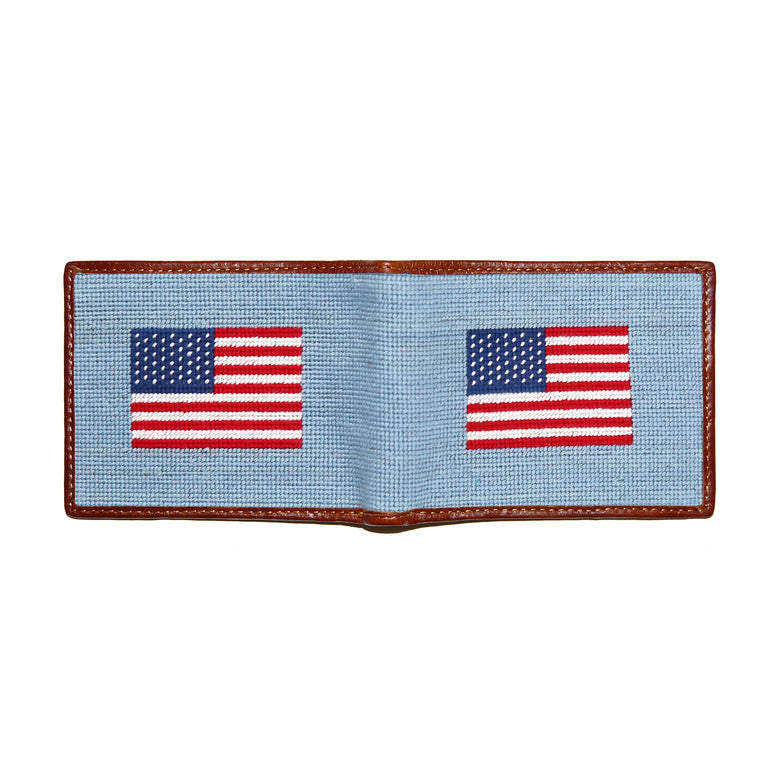 American flag navy and white needlepoint bi-fold wallet open to show both sides of the red and white stars and stripes pattern needlepoint design with brown leather trim.