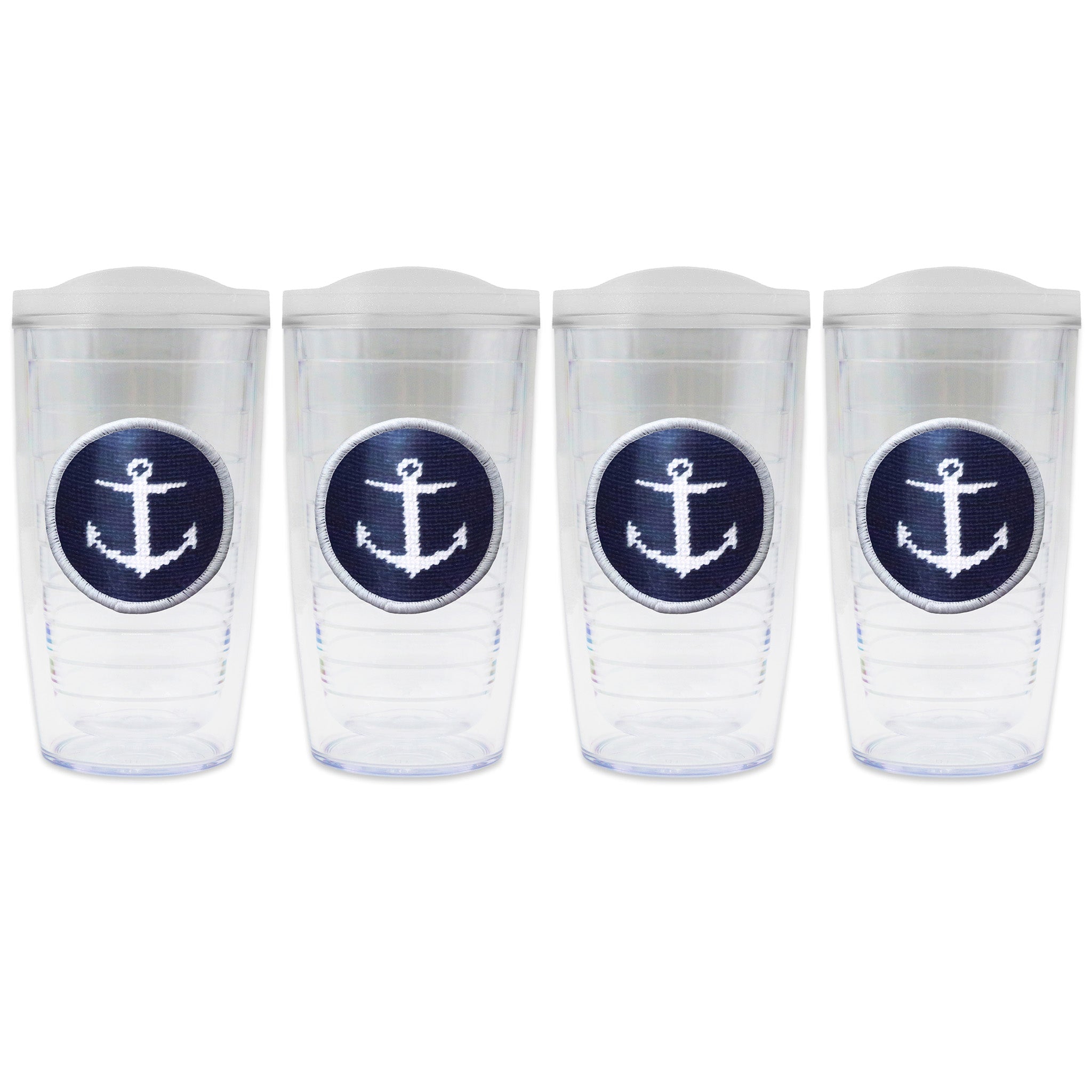 Set of 4 tumblers with lids on each in a line with a needlepoint logo in the center of each tumbler