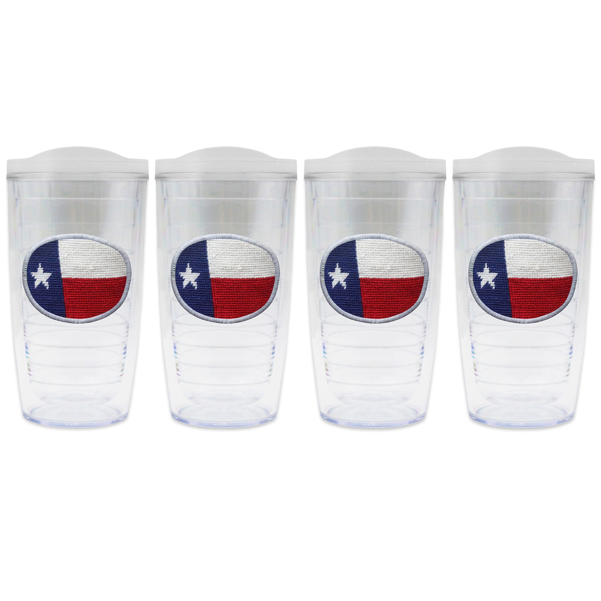 Set of 4 tumblers with lids on each in a line with a needlepoint logo in the center of each tumbler