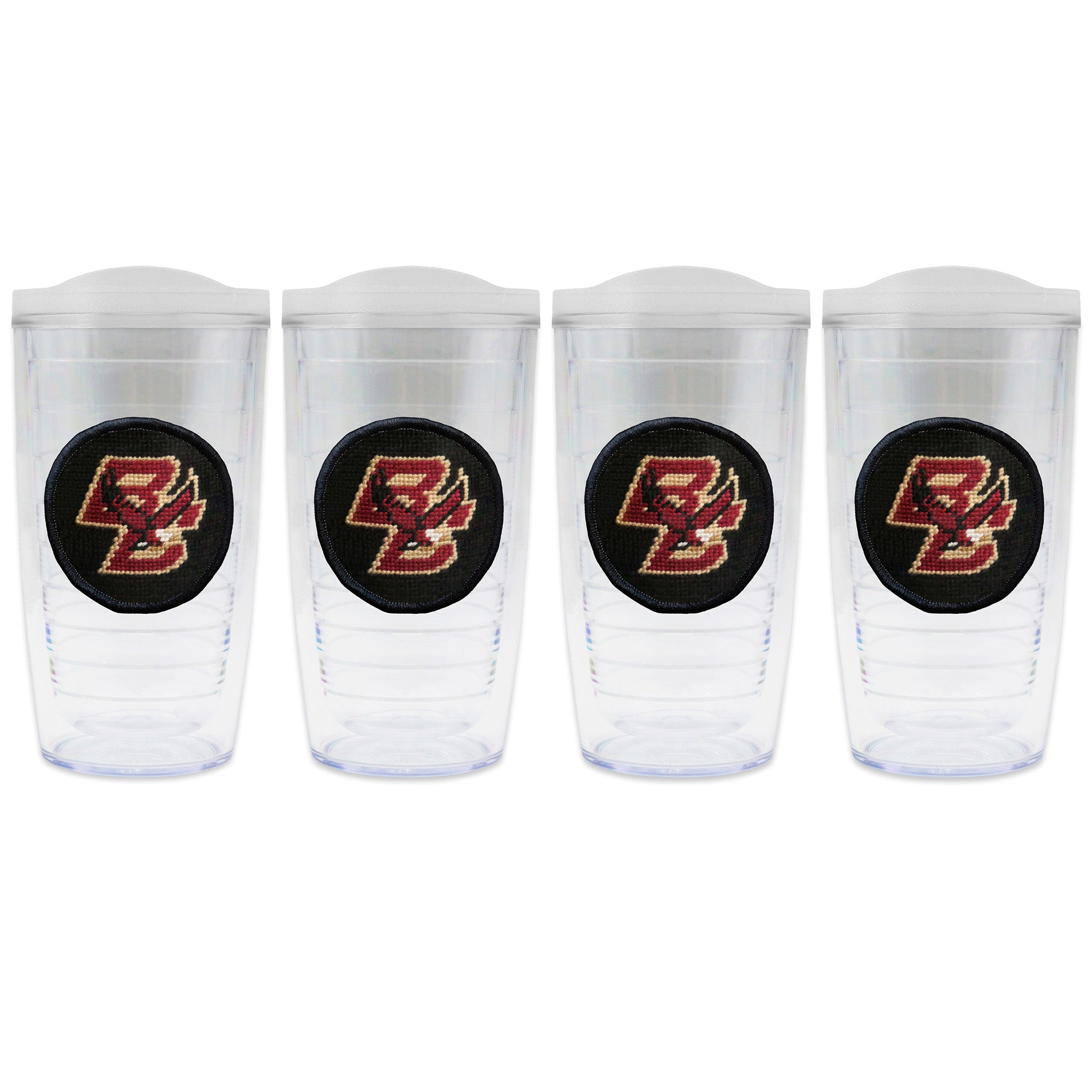 Set of 4 tumblers with lids on each in a line with a needlepoint logo in the center of each tumbler
