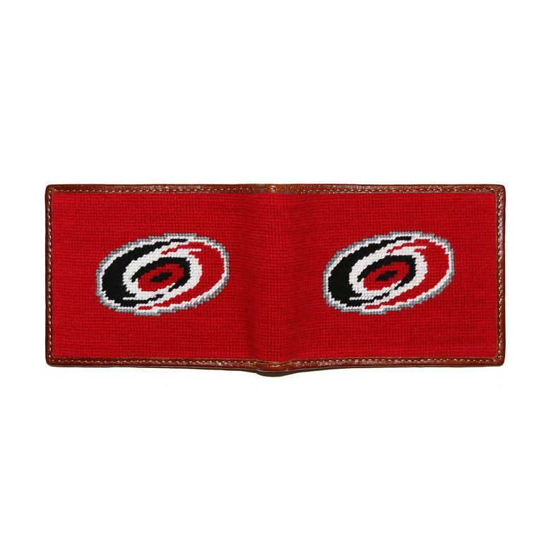 Carolina Hurricanes red and black needlepoint bi-fold wallet open to show both sides of the white “Storm Surge” logo needlepoint design with brown leather trim.