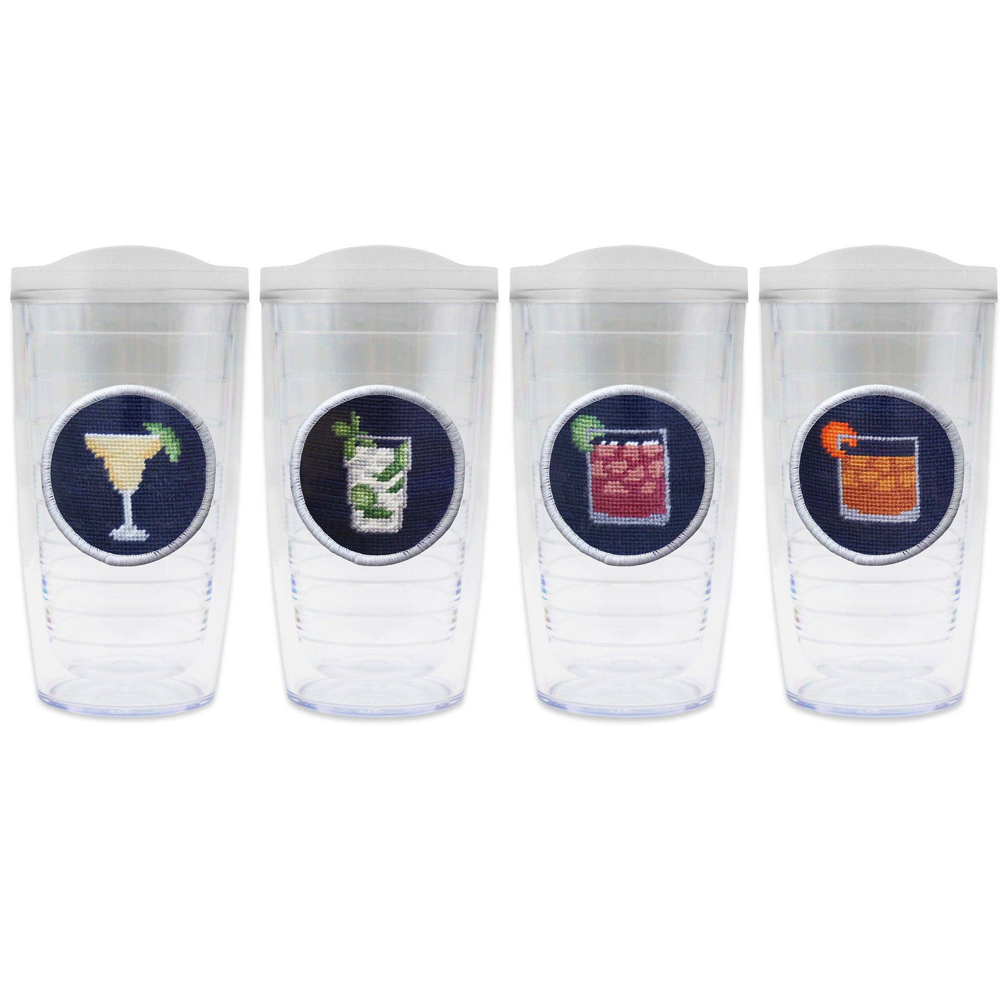 Set of 4 tumblers with lids on each in a line with a needlepoint logo in the center of each tumbler