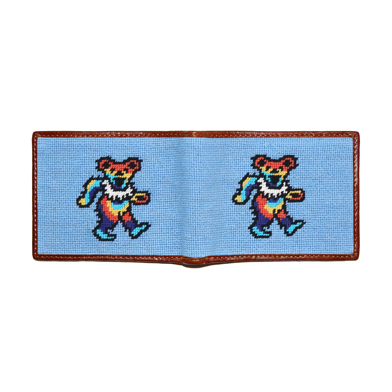 Dancing Bear tie-dye needlepoint bi-fold wallet in light blue with chestnut leather trim, shown from secondary angle showing interior needlepoint.