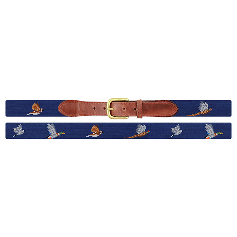 Flat view of Needlepoint Game Birds Belt Classic Navy with brown leather trim and a brass buckle