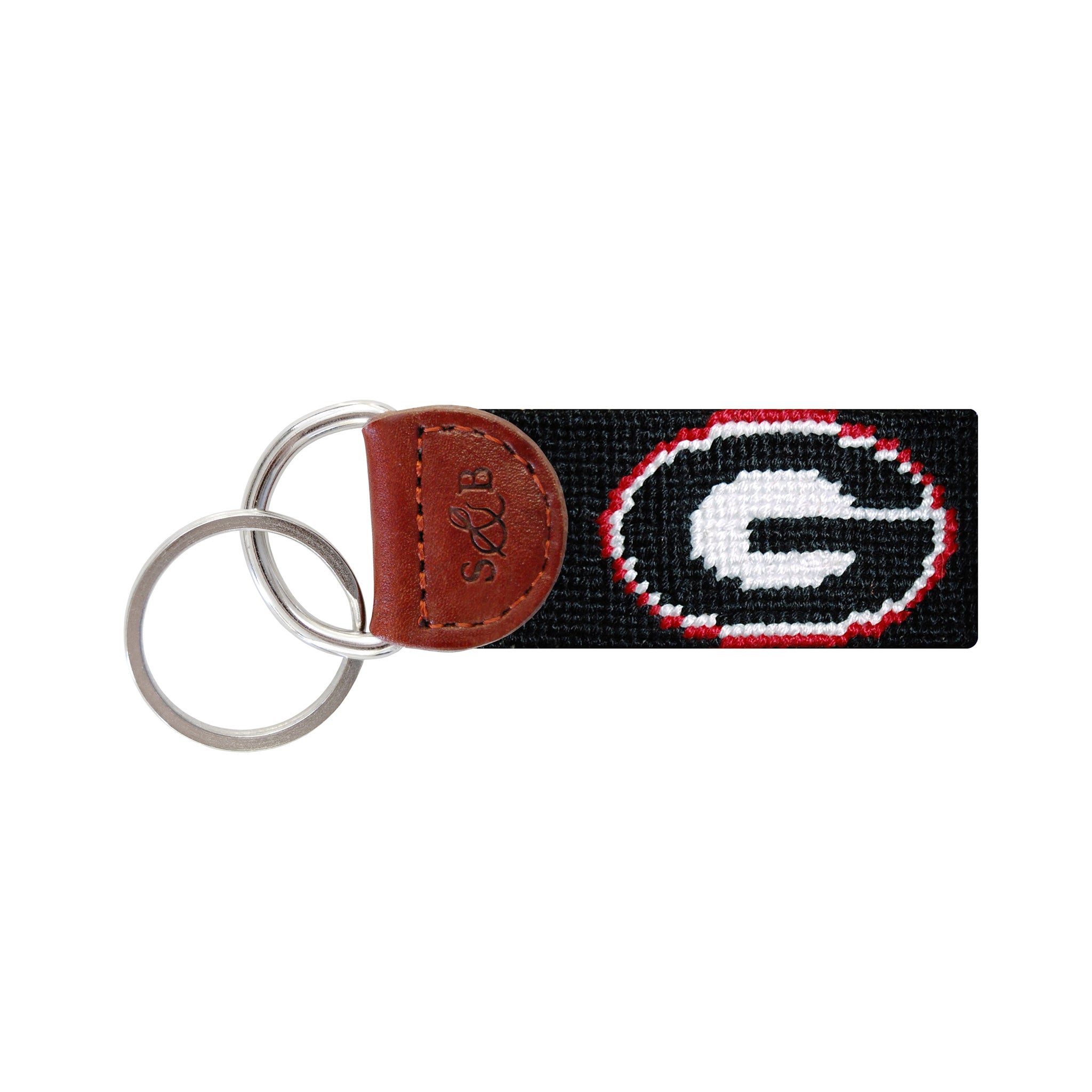 Black needlepoint key fob featuring a red Georgia “G” logo, brown leather trim, and a metal key ring.
