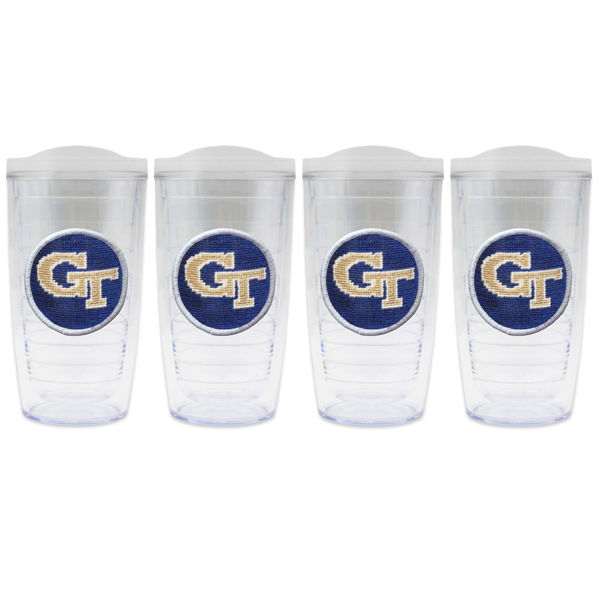 Set of 4 tumblers with lids on each in a line with a needlepoint logo in the center of each tumbler
