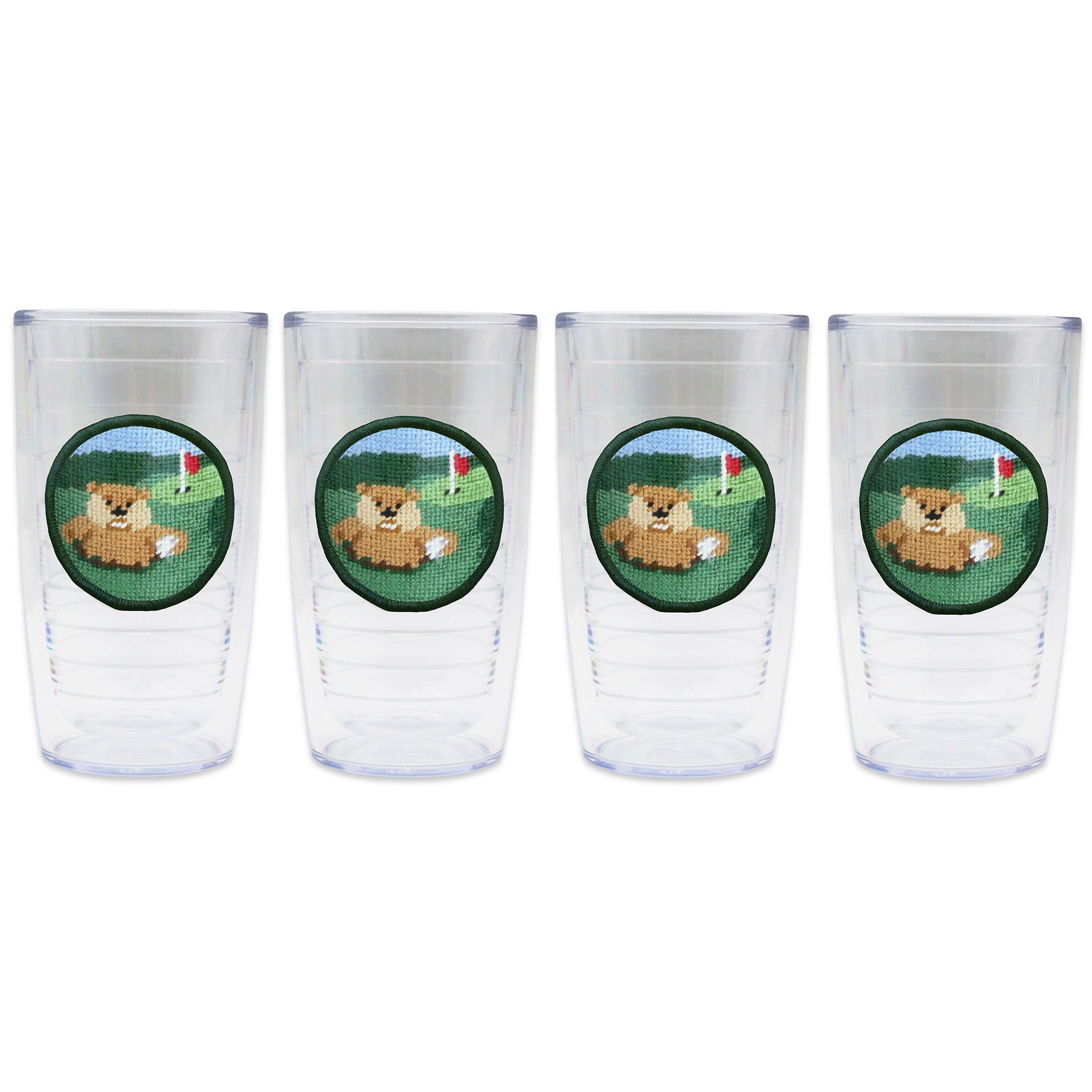 Set of 4 tumblers in a line with a needlepoint logo in the center of each tumbler