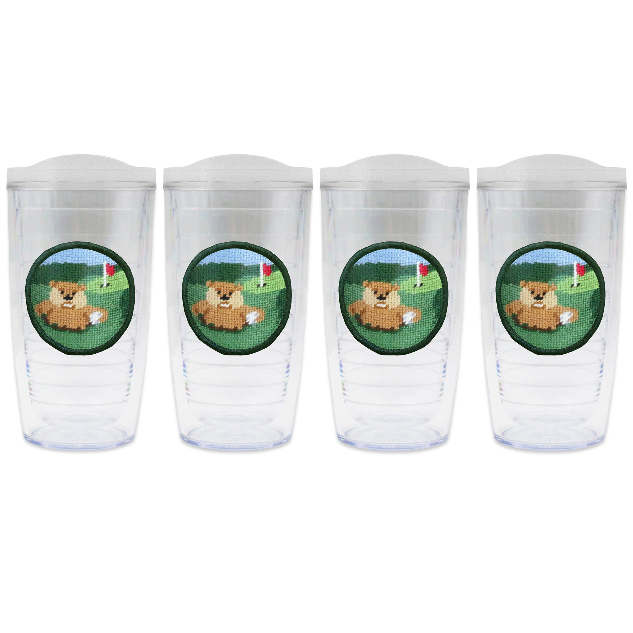 Set of 4 tumblers with lids on each in a line with a needlepoint logo in the center of each tumbler