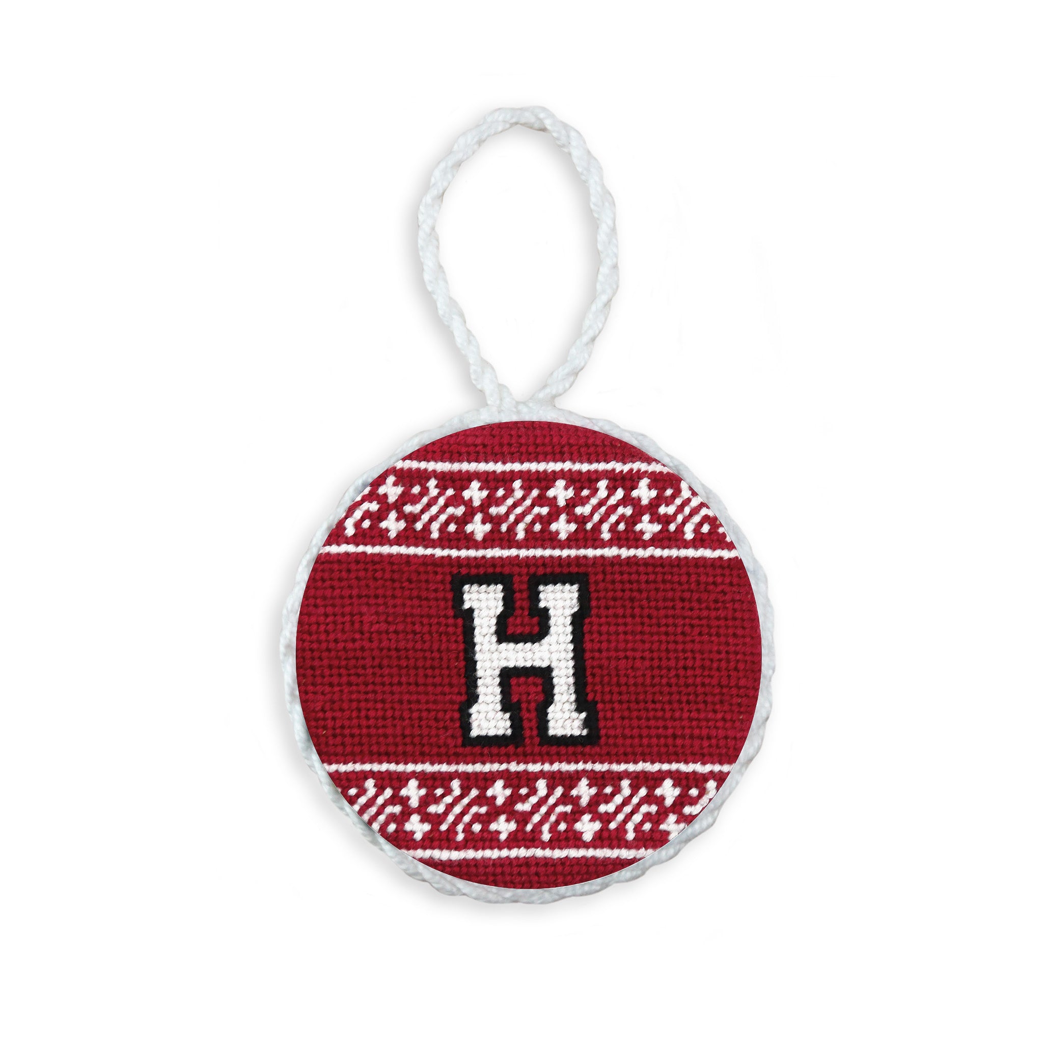 Garnet needlepoint ornament featuring the white Harvard “H” shield logo, finished with a white hanging cord.