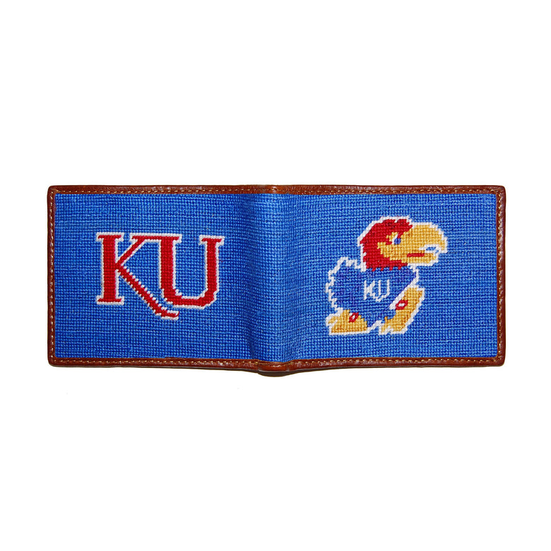 Kansas crimson and blue needlepoint bi-fold wallet open to show both sides of the white “Jayhawk” logo needlepoint design with brown leather trim.