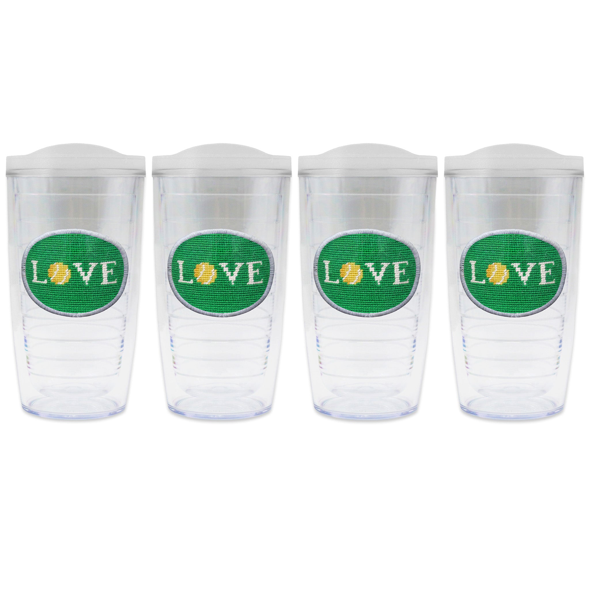 Set of 4 tumblers with lids on each in a line with a needlepoint logo in the center of each tumbler