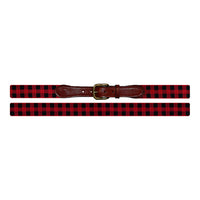 Red and black checkered belt with a brown leather, brass buckle on a white background