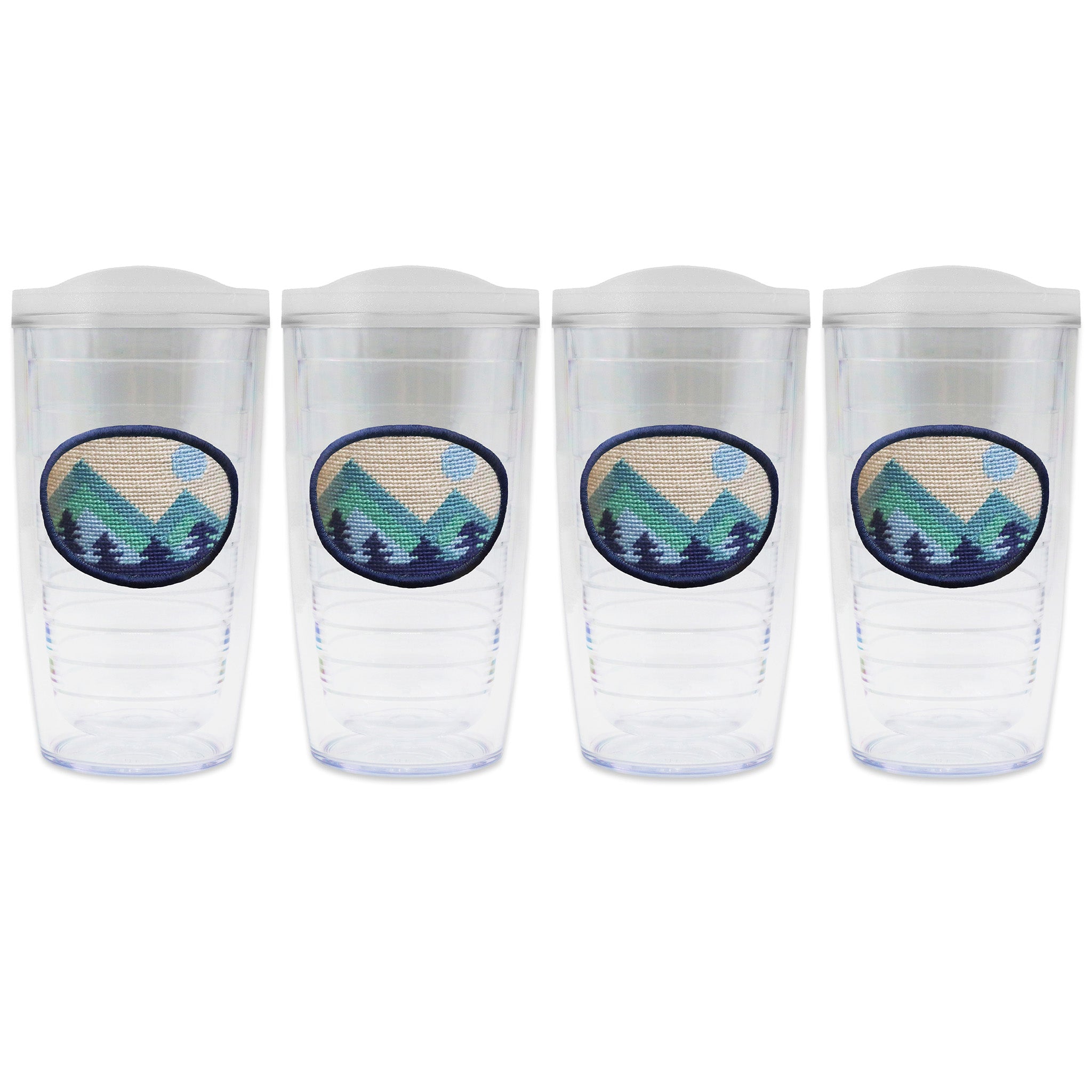 Set of 4 tumblers with lids on each in a line with a needlepoint logo in the center of each tumbler